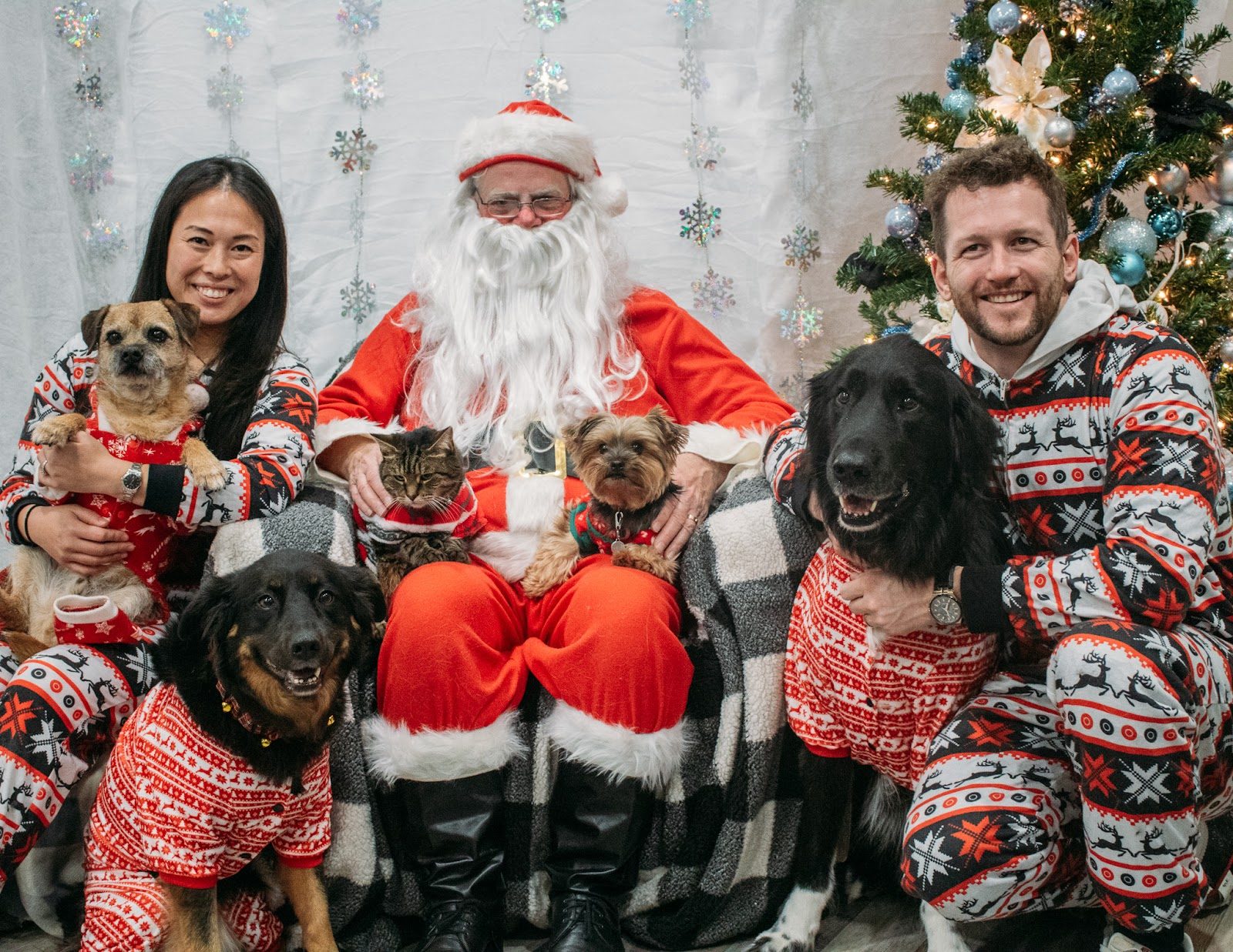 Pets and their families posing with Santa at Mac Animal Clinic